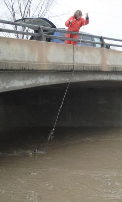 Saugeen Conservation staff member Martha Nicol samples water at a bridge on the Pine River.